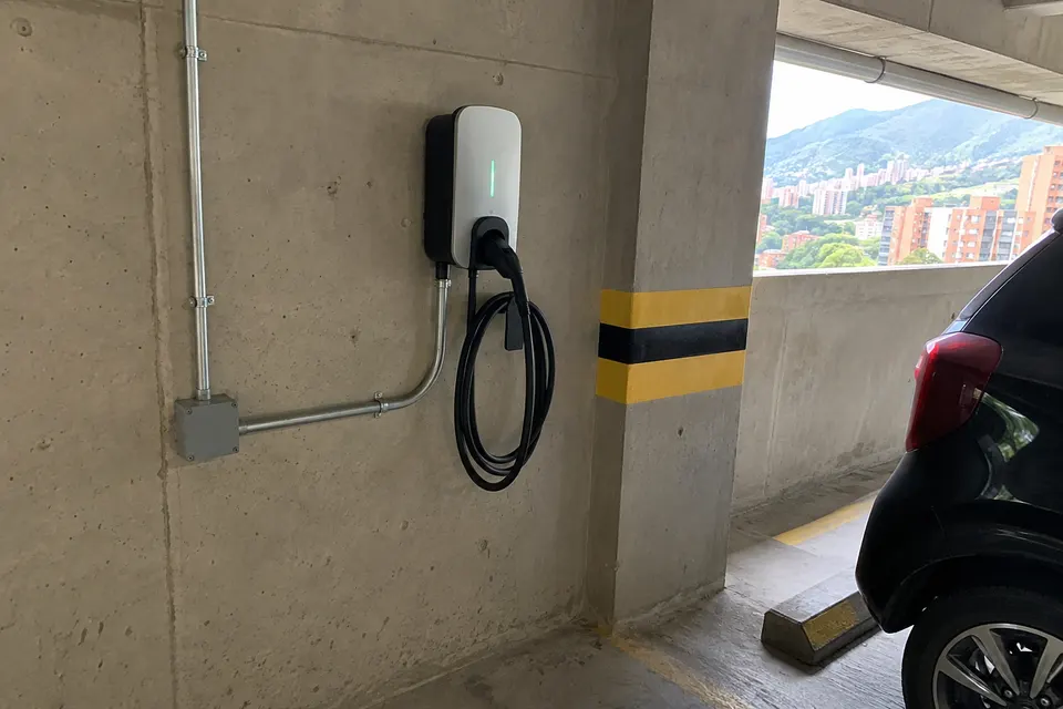 Escena ilustrativa de un cargador de vehículo eléctrico en un parqueadero residencial